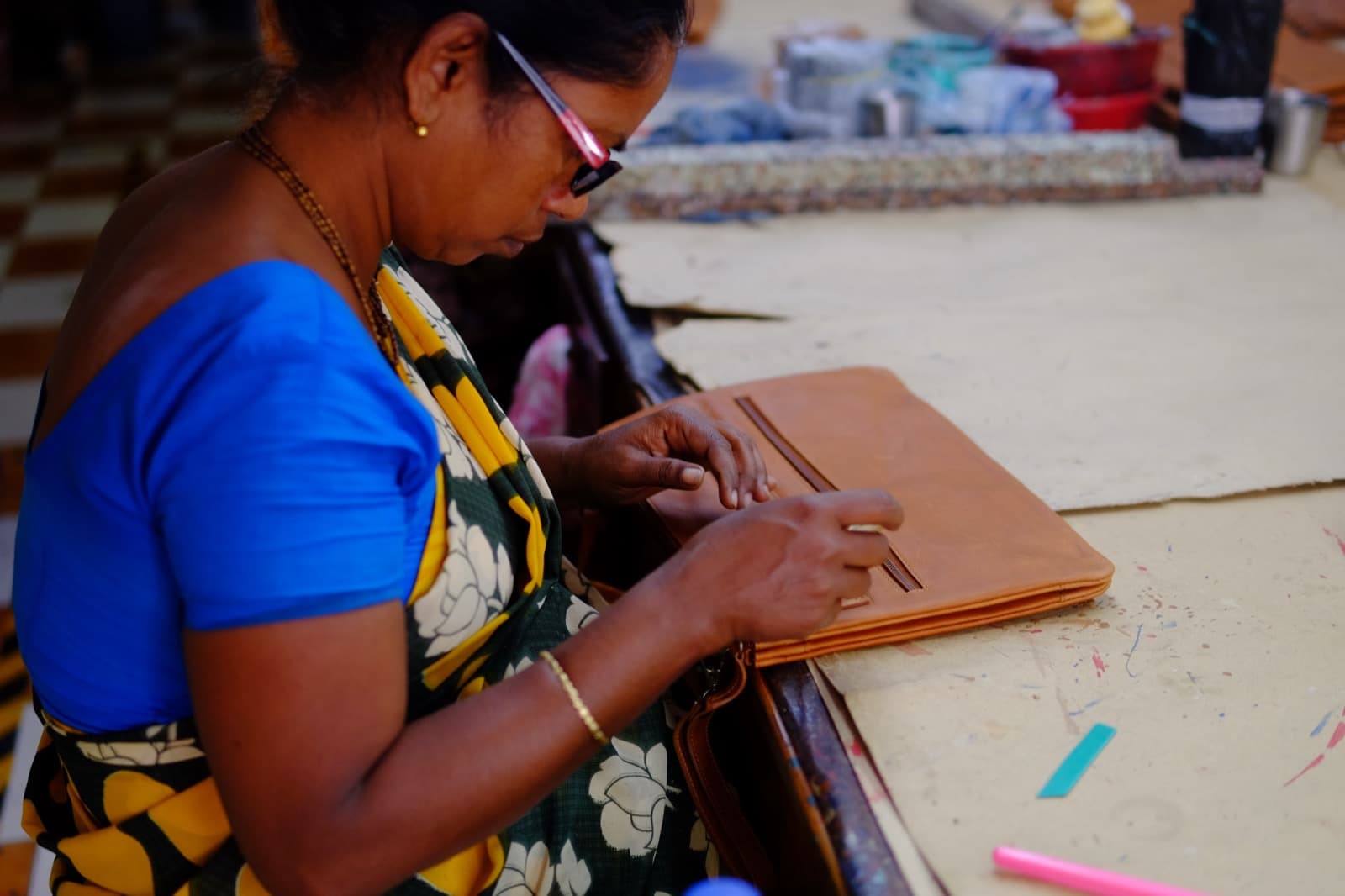 Woman artisan working on leather portfolio