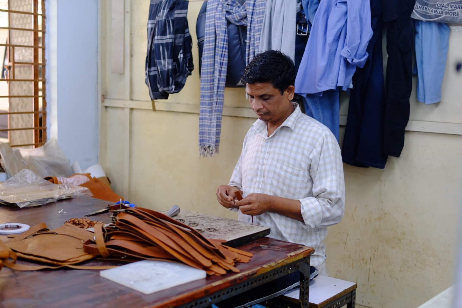 Artisan preparing leather pieces at workstation